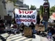 Protesters with signs against arms and genocide.