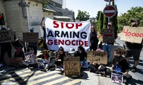 Protesters with signs against arms and genocide.