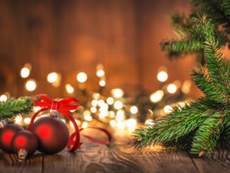 Red baubles and pine branches, festive lights.