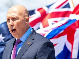 Person speaking with Australian flag behind them.