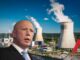 Man in suit with industrial plant background.