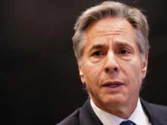 Man in suit with a neutral expression.