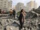 People amidst rubble in a destroyed city.