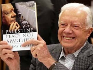 Man holding a book, smiling at event.