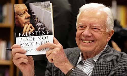Man holding a book, smiling at event.