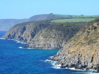 Rocky coastline with cliffs and blue ocean.