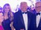 Four people smiling at formal event.