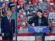 Two men speaking at a political rally.