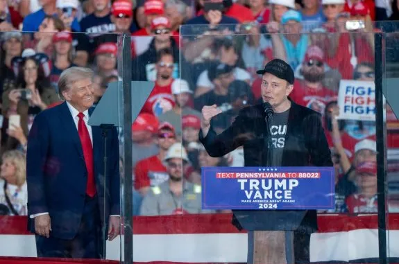 Two men speaking at a political rally.