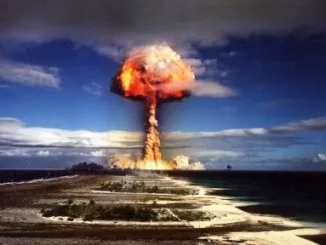 Nuclear explosion with mushroom cloud over island.
