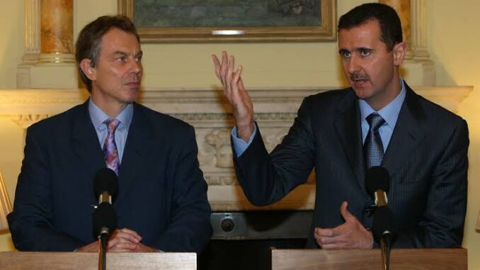 Two men at podiums, one making a gesture