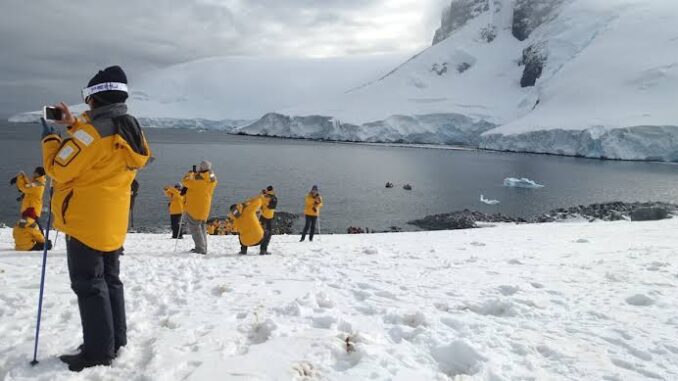 People in yellow jackets on snowy landscape.