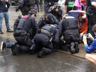 Police officers detaining a person during protest.