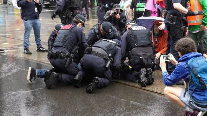 Police officers detaining a person during protest.