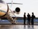 People meeting beside a private jet.