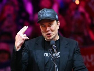Man speaking at event with microphone.