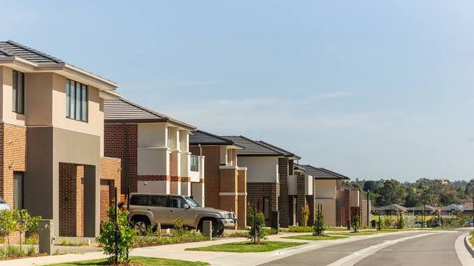 Modern suburban street with brick houses.