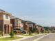 Modern suburban street with brick houses.