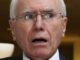 Surprised elderly man wearing glasses indoors.