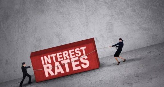 People pulling large "Interest Rates" block. People pulling large "Interest Rates" block.