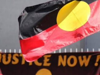 Aboriginal flag with "Justice Now" banner.