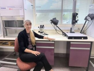 Woman sitting in a laboratory setting.