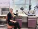 Woman sitting in a laboratory setting.