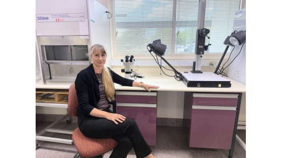 Woman sitting in a laboratory setting.