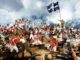 Historic battle scene with soldiers and flag.