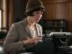 Woman in vintage attire using typewriter.