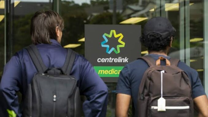 Two people outside Centrelink office entrance. Two people outside Centrelink office entrance.