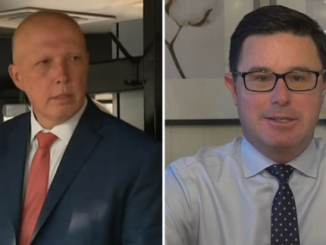 Two men in suits, one wearing glasses.