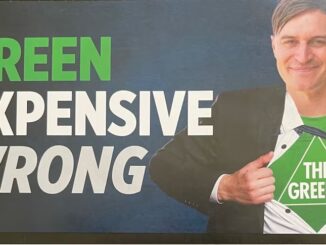 Man opening shirt revealing The Greens logo.