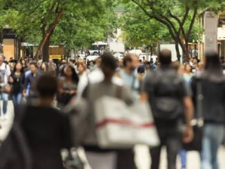 Busy city street with many pedestrians walking.