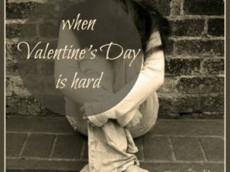 Person sitting against brick wall, feeling sad.