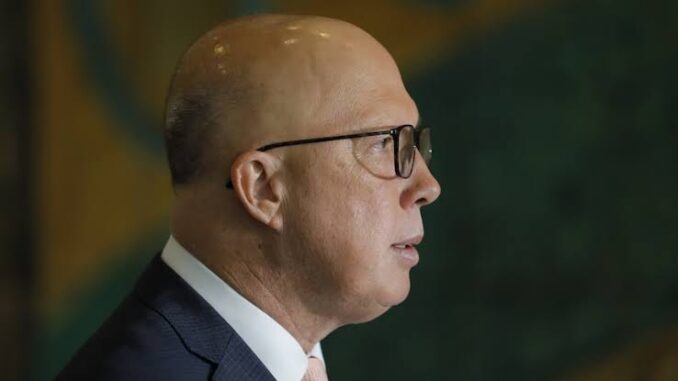 Man in suit and glasses, side profile.
