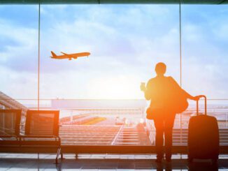 Traveler watching airplane take off at airport.