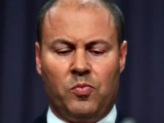 Man with serious expression, eyes closed.