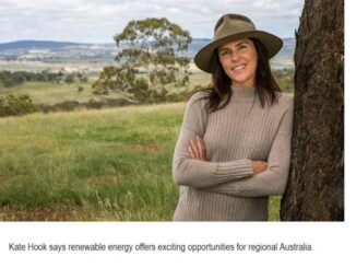 Woman in a hat standing by tree.