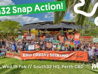 Protesters with signs against forest mining.