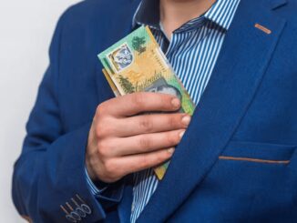 Man putting Australian dollars in jacket pocket.