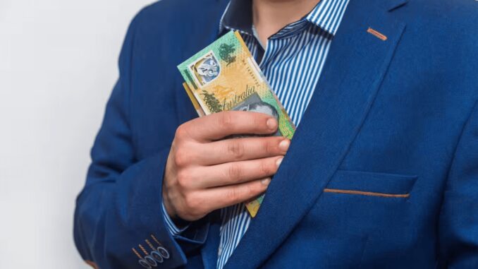 Man putting Australian dollars in jacket pocket. Man putting Australian dollars in jacket pocket.