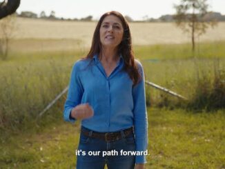 Woman speaking outdoors in a field.