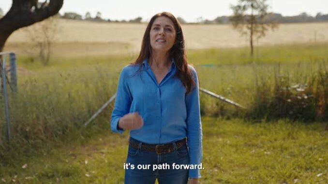 Woman speaking outdoors in a field.