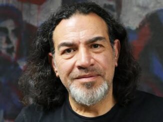 Man with long hair and beard, abstract background.
