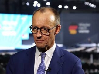 Man in suit speaking at conference event.
