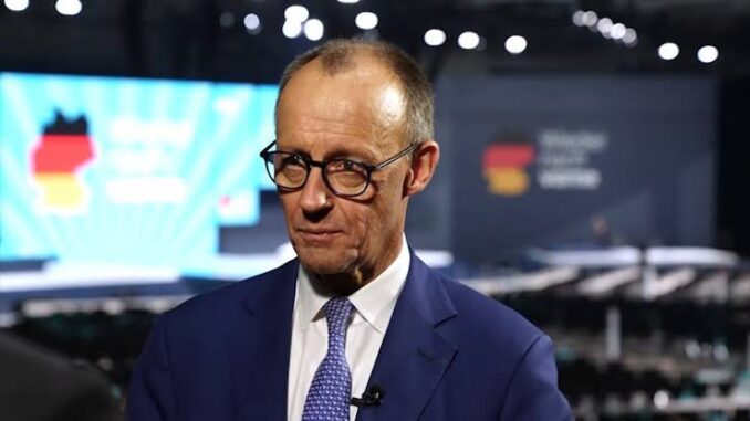 Man in suit speaking at conference event.