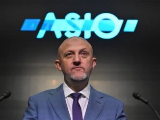 Man in suit speaking at ASIO event.