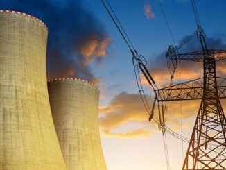 Cooling towers and power lines at sunset.