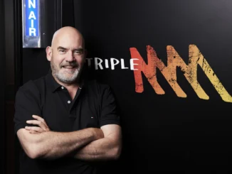 Man standing next to Triple M logo.